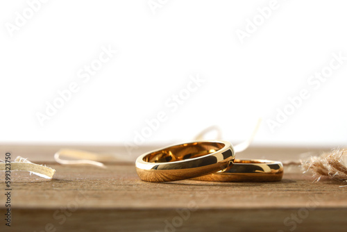 Gold rings on rustic wooden table and white isolated background