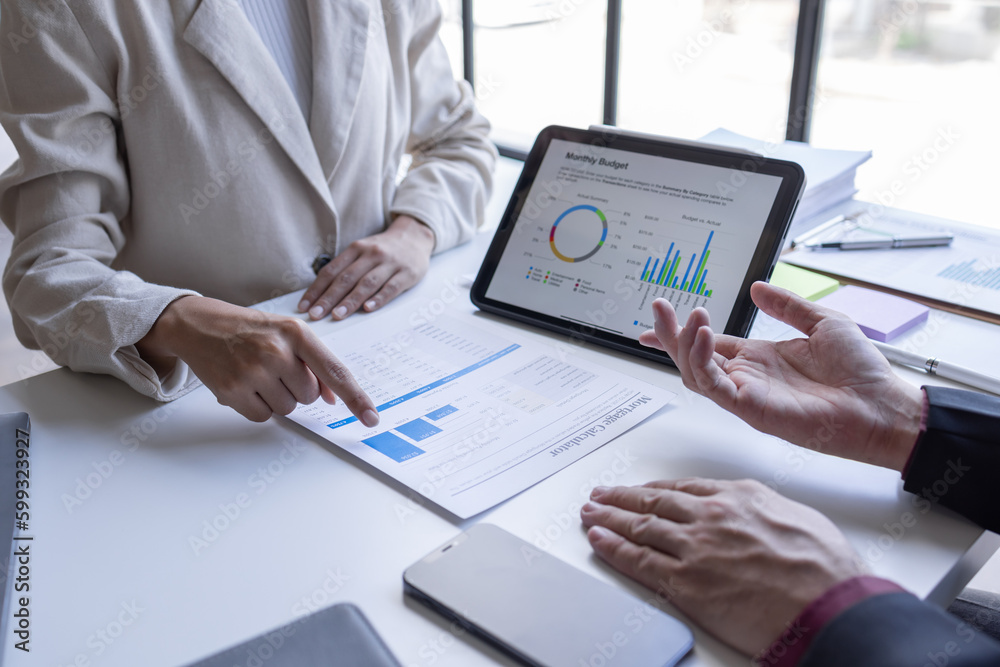 Team of confident business people point to graphs and charts to analyze market data, balance sheet, account, net profit to plan new sales strategies to business increase production capacity.	