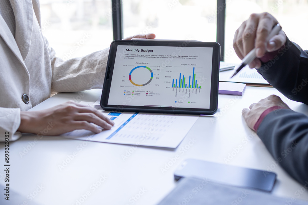 Team of confident business people point to graphs and charts to analyze market data, balance sheet, account, net profit to plan new sales strategies to business increase production capacity. Team of confident business people point to graphs and charts to analyze market data, balance sheet, account, net profit to plan new sales strategies to business increase production capacity.
