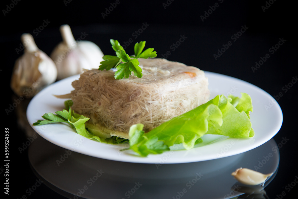 Boiled chicken meat aspic in meat gelatin broth in a plate Boiled chicken meat aspic in meat gelatin broth in a plate