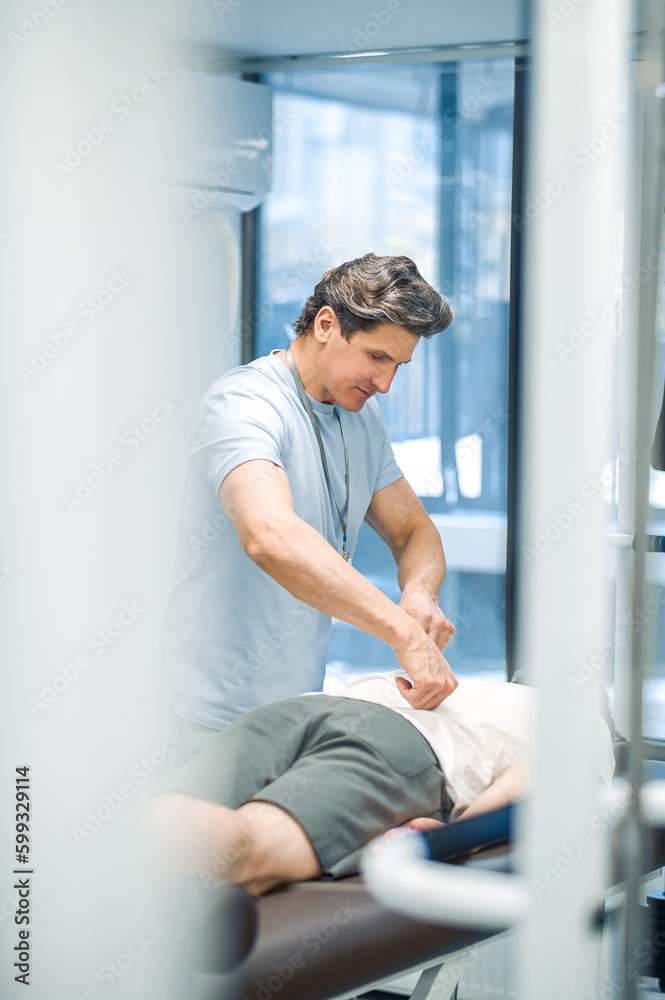 Manual therapist working with patient back and looking involved