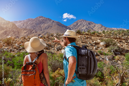 dos excursionistas turistas mirando el cerro y señalando al paisaje montañosos desérticos en el Valle del Elqui photo