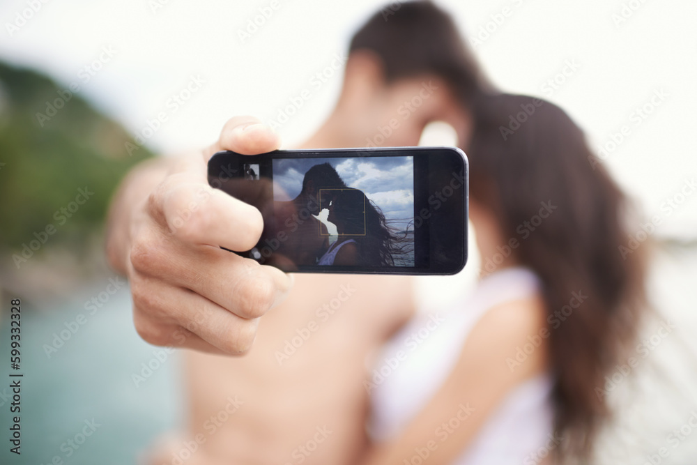 Capturing summer memories. an affectionate young couple taking a self portrait while enjoying a boat ride.
