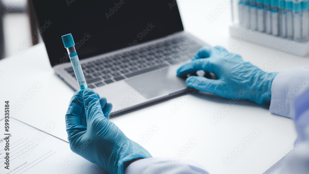 Lab assistant, a medical scientist, a chemistry researcher holds a glass tube through the blood sample, does a chemical experiment and examines a patient's blood sample. Medicine and research concept. Lab assistant, a medical scientist, a chemistry researcher holds a glass tube through the blood sample, does a chemical experiment and examines a patient's blood sample. Medicine and research concept.