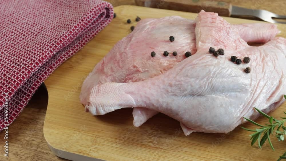 cuisses de canard cru, en gros plan, sur une planche à découper
