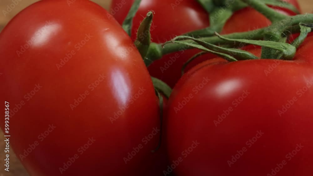 grappe de tomates rouges, en gros plan, sur une planche à découper