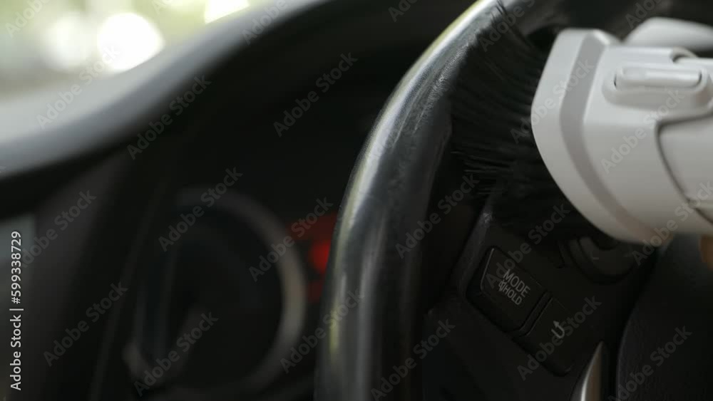 Close-up of a vacuum cleaner head sucking the dust from the steering wheel of a car Close-up of a vacuum cleaner head sucking the dust from the steering wheel of a car