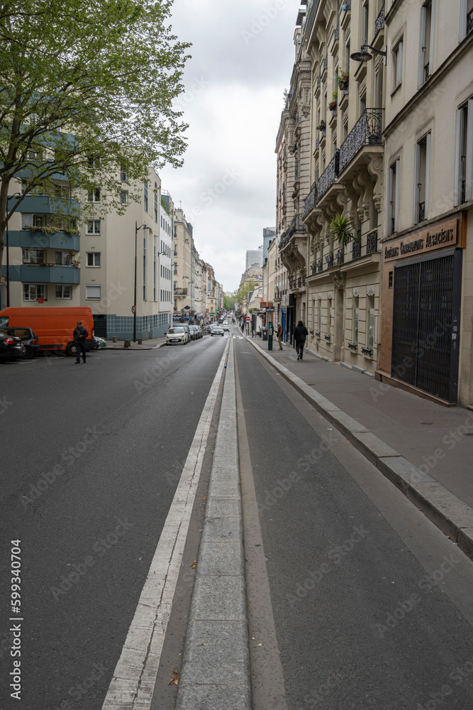 Paris, France - 05 01 2023: Ourcq canal. View of a long downhill street and a clean site bike lane.