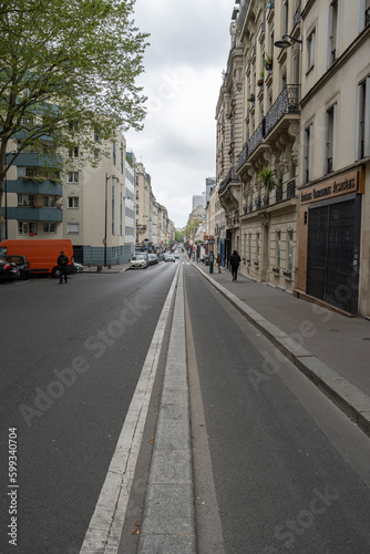 Fototapeta Naklejka Na Ścianę i Meble -  Paris, France - 05 01 2023: Ourcq canal. View of a long downhill street and a clean site bike lane.