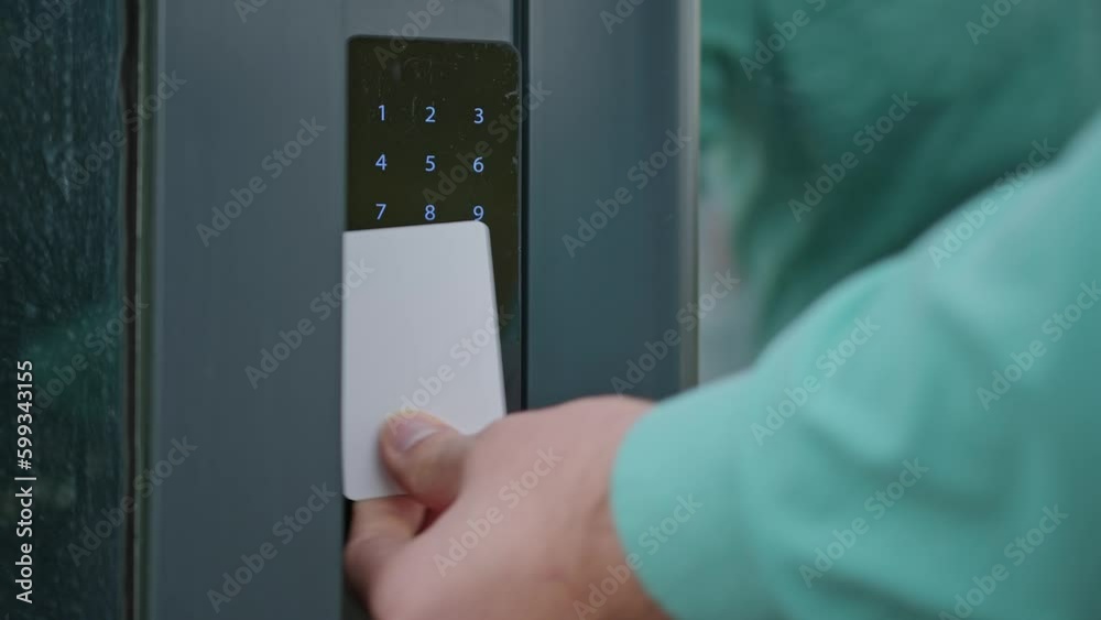 Close-up of people applying a white plastic key card to an electronic lock. Modern security system. 