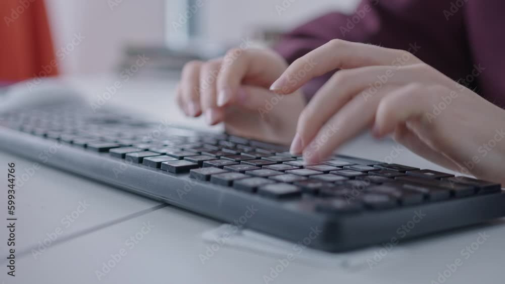 Close-up of a person's hands typing on a plastic gaming keyboard with multi-colored backlight. Writing software Close-up of a person's hands typing on a plastic gaming keyboard with multi-colored backlight. Writing software