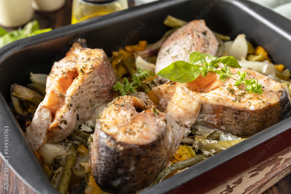 Healthy baked fish salmon steaks with basil, green beans and sweet peppers on a rustic table. Low carb dinner, healthy nutrition concept, diet menu.