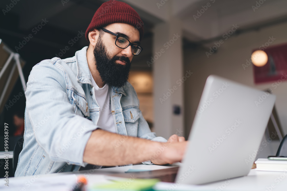 Bearded man working on laptop in office