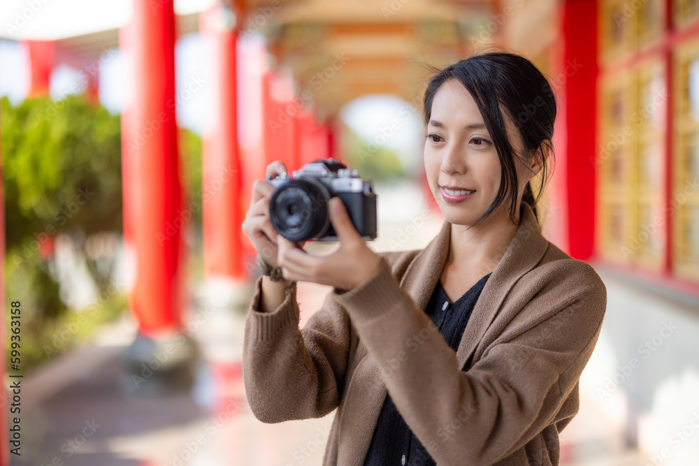 Travel woman use digital camera to take photo in chinese temple