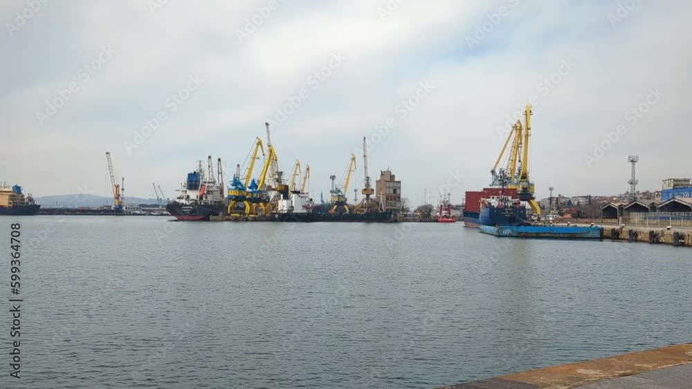 View of the industrial port with cranes and ships for loading and unloading. The concept of transport, logistics or other industrial services and goods View of the industrial port with cranes and ships for loading and unloading. The concept of transport, logistics or other industrial services and goods
