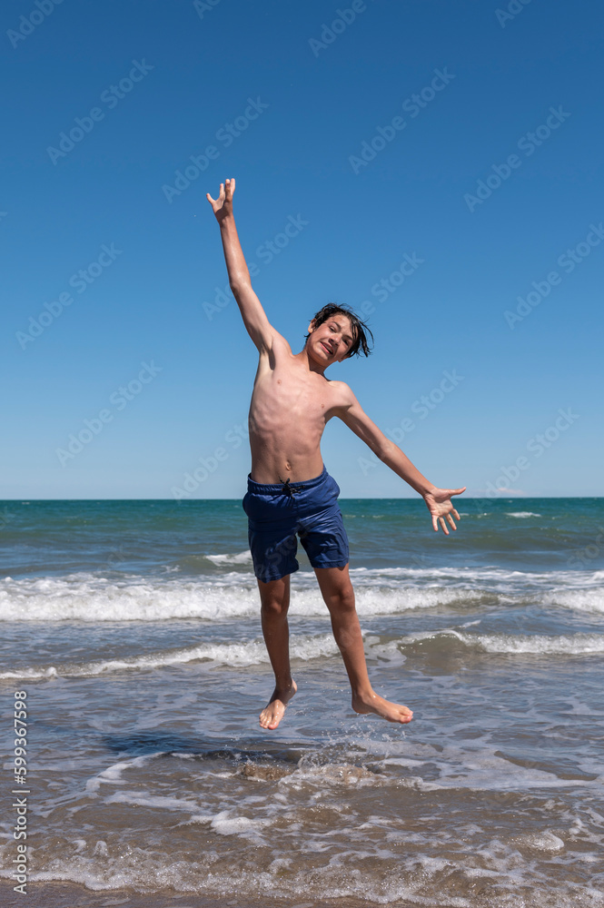 Young man jumping on the sea shore happy in his summer vacation. Young man jumping on the sea shore happy in his summer vacation.
