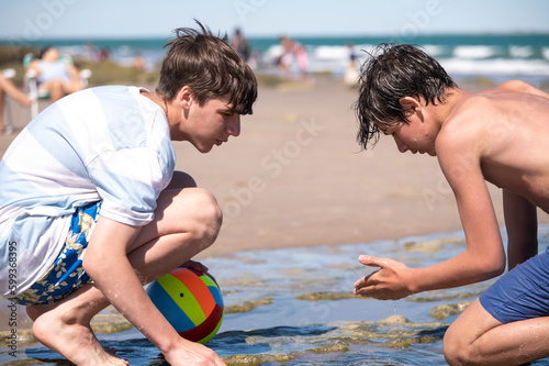 фотографія Amigos totalmente concentrados mientras realizan juegos en la arena de la Costa Atlántica,  Playa Las Grutas, Rio Negro, Argentina