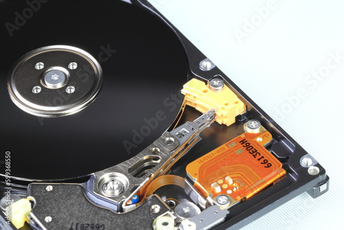 Close up view of internal computer hard drive 2.5" SAS, can see disk surface and head with shallow focus isolated on white background.