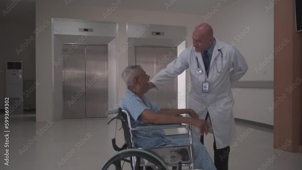 male doctor having discussion with the elderly patient on the wheel chair about his condition after operation in the hospital. male doctor having discussion with the elderly patient on the wheel chair about his condition after operation in the hospital.