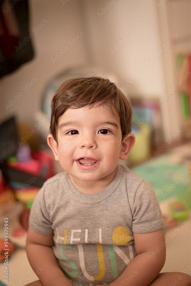 Cute little boy looking at camera while sitting on the floor at home. Childhood concept. Cute little boy looking at camera while sitting on the floor at home. Childhood concept.