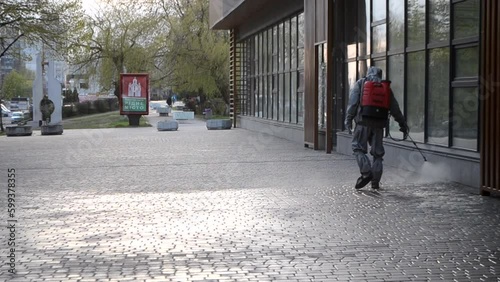 Wallpaper Mural Man in protective suit spraying antiseptic solution on sidewalk in city. Persona disinfecting spray chemicals to preventing spread coronavirus. Sanitary measures in public place. Coronavirus pandemic Torontodigital.ca