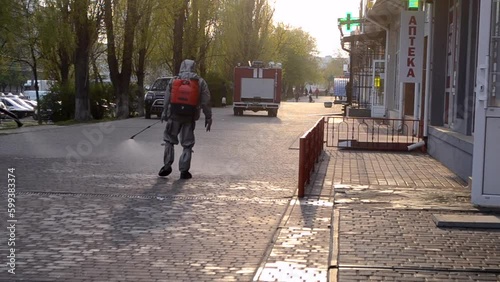 Wallpaper Mural Man in protective suit spraying antiseptic solution on sidewalk in city. Persona disinfecting spray chemicals to preventing spread coronavirus. Sanitary measures in public place. Coronavirus pandemic Torontodigital.ca