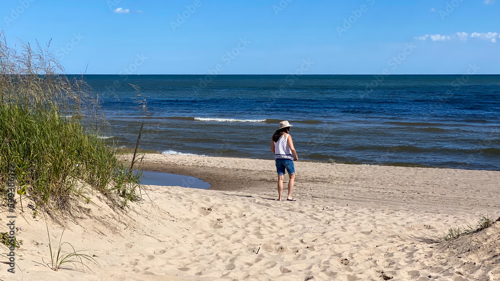 woman walking path and beach to Lake Michigan