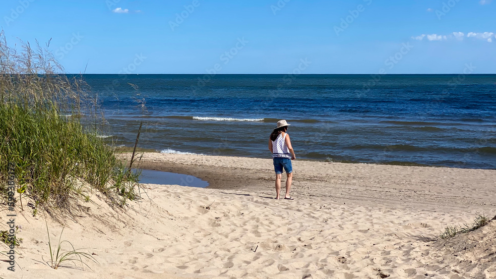 woman walking path and beach to Lake Michigan woman walking path and beach to Lake Michigan