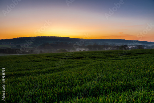 Colourful sunrise on a summer morning with a little fog on the ground and spectacular views over the Dutch hillside near the village of Kuttingen