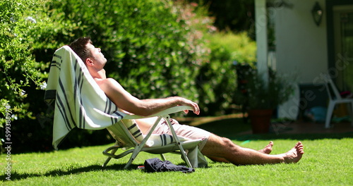 Man relaxing outside home backyard sunbathing photo