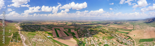 Obraz na płótnie Aerial panorama of patchwork fields with shadows cast by clouds and a rural settlement w salonie