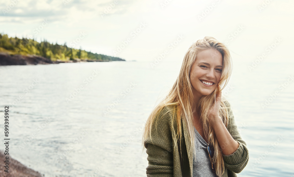 Theres plenty of smiles to be made in nature. a young woman spending a day at the lake.