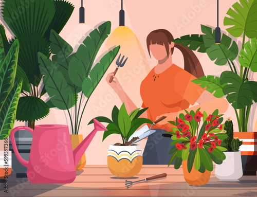 Young woman caring for houseplants. Daily life and everyday routine scene by young woman in cozy interior with houseplants. Home gardening and growing houseplants.