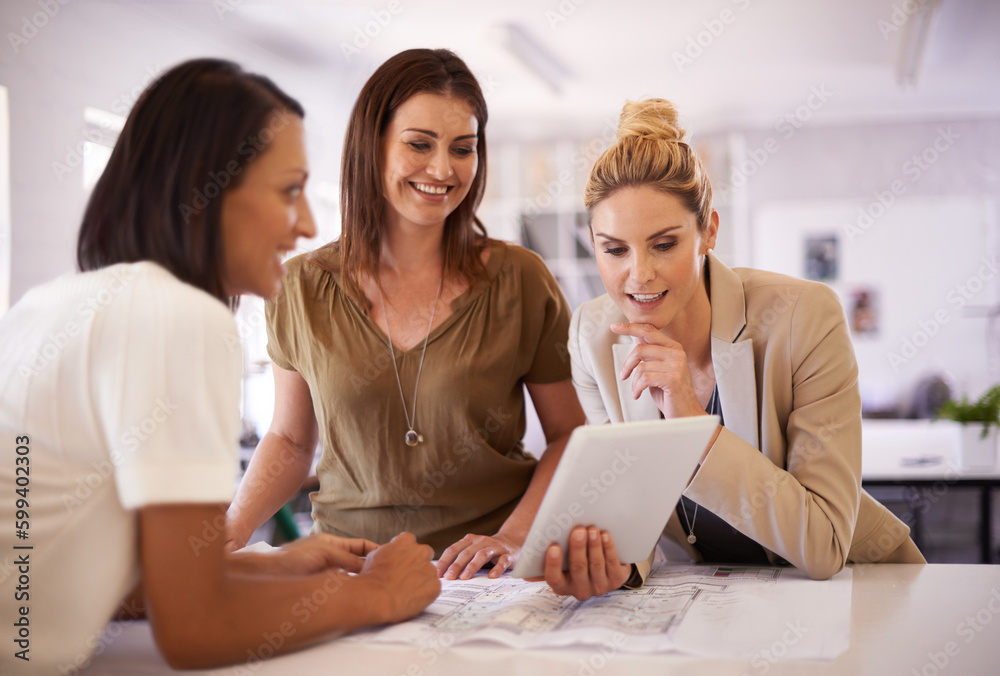 Getting some design inspiration. Three female colleagues having a discussion while gathered around a digital tablet. Getting some design inspiration. Three female colleagues having a discussion while gathered around a digital tablet.