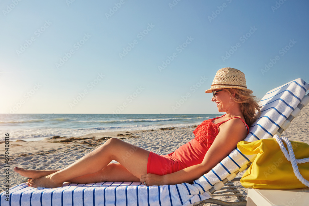 Fototapeta premium My view all day today. an attractive woman lying on a lounger at the beach.