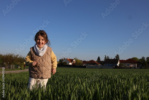 Happy little girl walking in the meadow  © Kate Wieser