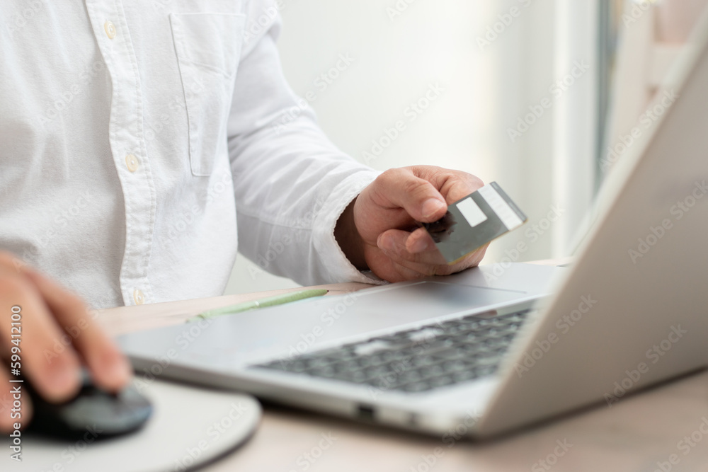 Person using their black debit card front their laptop with copy space Person using their black debit card front their laptop with copy space
