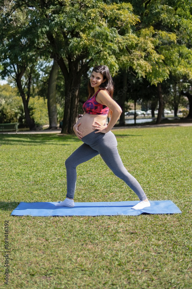 Fototapeta premium Beautiful pregnant woman doing sport in summer park.