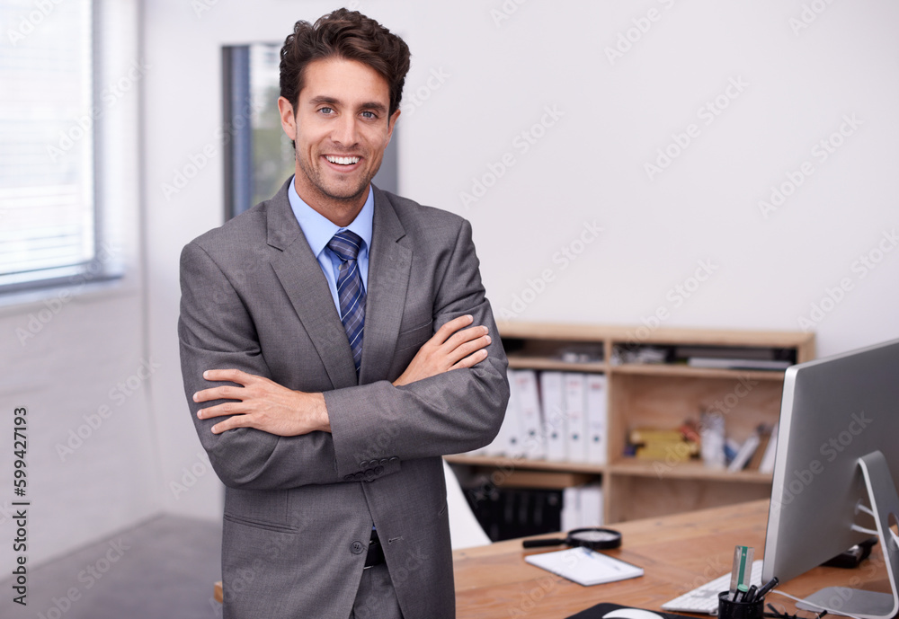 Proud of his workspace. A handsome young businessman standing in his office confidently. Proud of his workspace. A handsome young businessman standing in his office confidently.