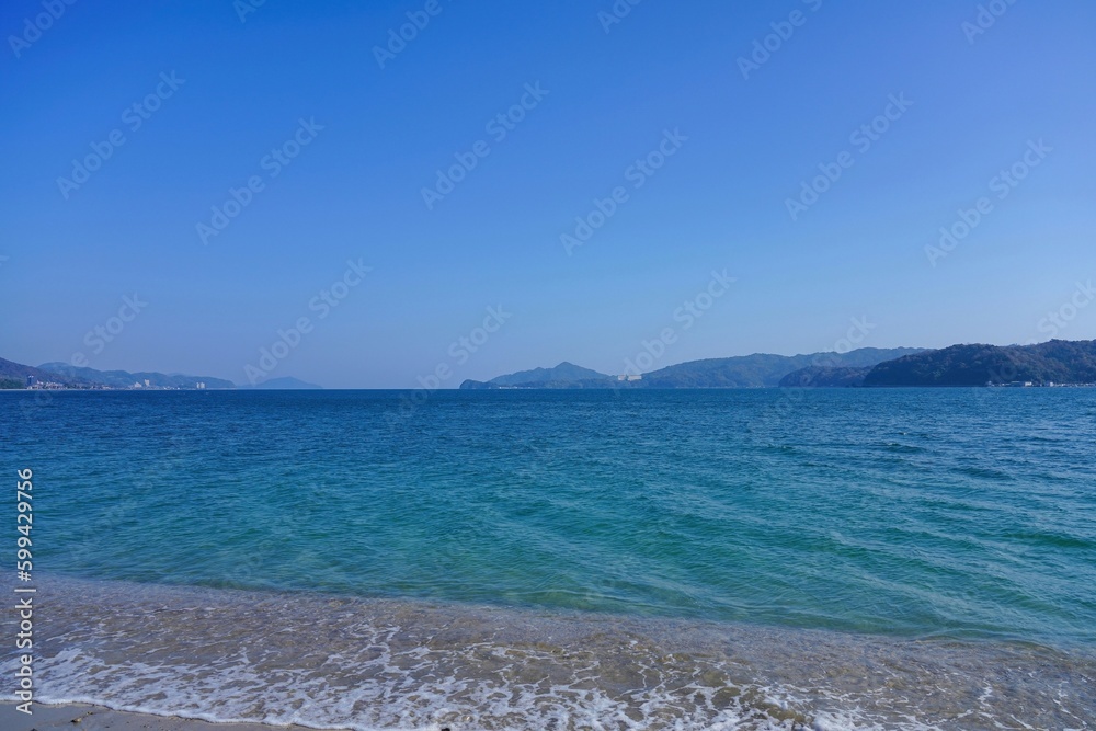 Obraz premium 天橋立の砂浜から見た穏やかな宮津湾の情景 