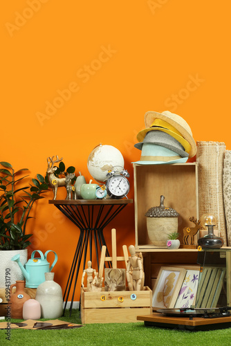 Fotografija Many different items near orange wall in room. Garage sale