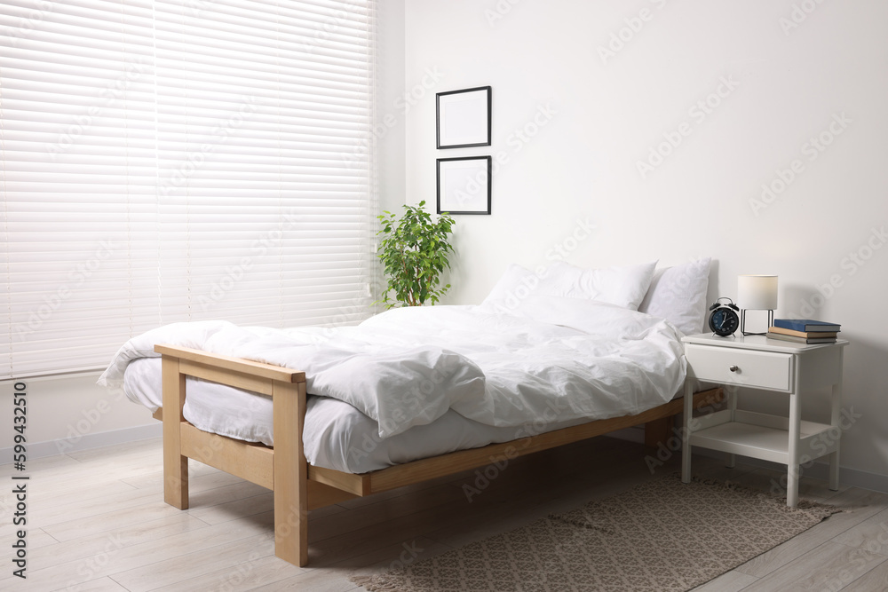 Fototapeta premium Stylish light room with comfortable bed and bedside table. Interior design