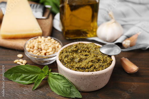 Tasty pesto sauce and ingredients on wooden table, closeup