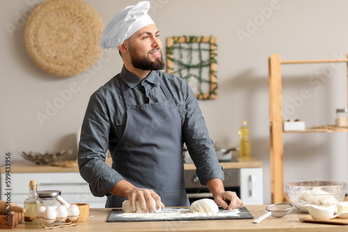 Smiling male chef kneading ...