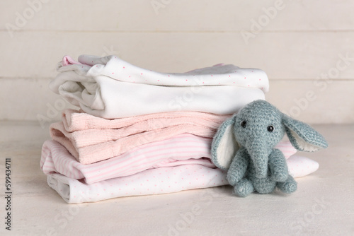 Stack of baby clothes and k...