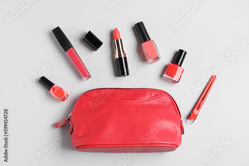 Composition with cosmetic bag  nail polishes and lipsticks on light background