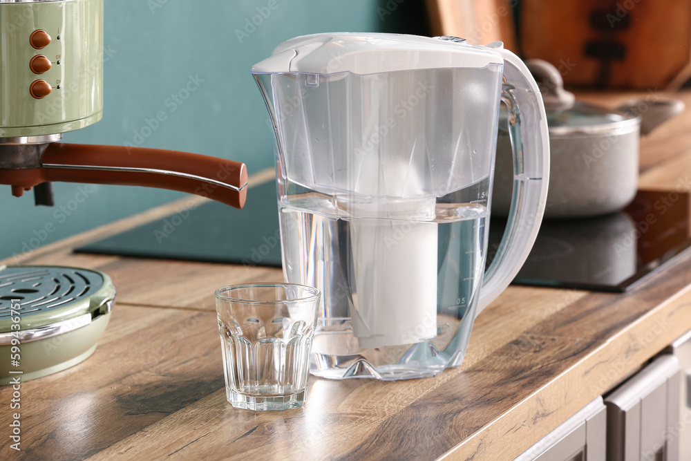 Filter jug and glass of water on kitchen counter Stock Photo | Adobe Stock
