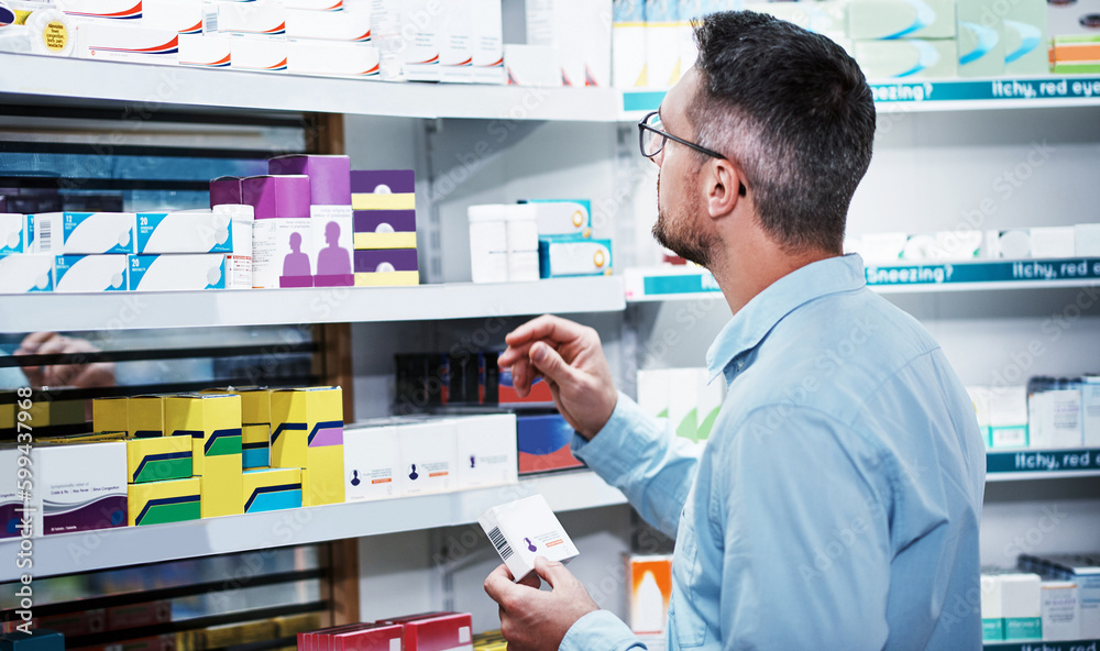 Comparing products to make the best choice. a mature man looking at products in a pharmacy.