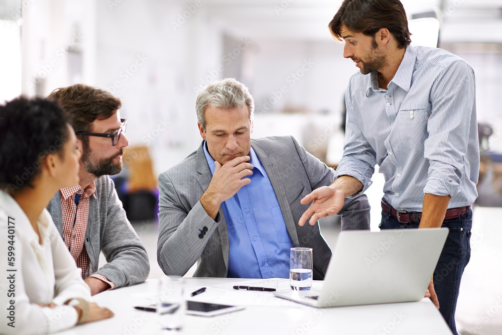 Leading his team through the creative process. a group of a diverse group of business professionals having a meeting. Leading his team through the creative process. a group of a diverse group of business professionals having a meeting.