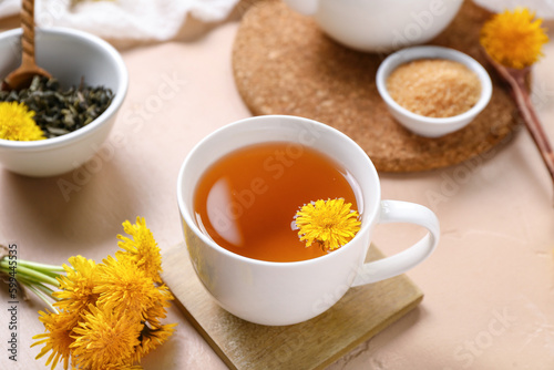 Cup of healthy dandelion tea on beige background